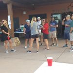 Large group of people talking with cups on their hands
